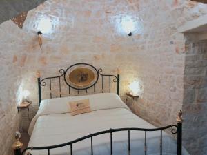 a bedroom with a bed in a stone wall at B&B La Rosa dei Trulli Alberobello in Alberobello