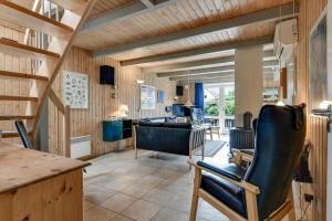 a living room with wooden walls and a table and chairs at BV348-Blavand-Fyrgarden-19 in Blåvand