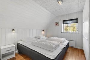 a bedroom with a large bed in a white room at BV185-Blavand-Degnevangen-5 in Blåvand +28 photos