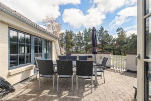 a patio with a table with chairs and an umbrella at BV185-Blavand-Degnevangen-5 in Blåvand