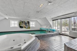 a large bathroom with a tub and a swimming pool at BV185-Blavand-Degnevangen-5 in Blåvand