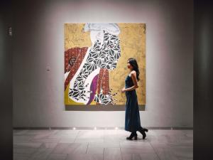 a woman is standing in front of a painting at Pullman Tokyo Tamachi in Tokyo