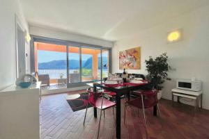 a dining room with a table and chairs with a view at Gaeta 'Lake View' in San Siro