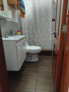 a bathroom with a toilet and a shower curtain at Casa Almendro in Puerto Villamil