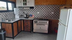 a kitchen with a stove and a white refrigerator at La Su in Duggan