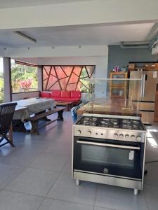 a kitchen with a stove and a table in a room at Fare Te Ava Iti in Teahupoo