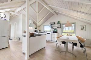 a kitchen and dining room with a table and chairs at BV366-Blavand-Skaubjergvej-4 in Blåvand