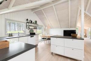 a kitchen with white cabinets and a black counter top at BV366-Blavand-Skaubjergvej-4 in Blåvand +15 photos