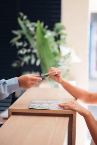 a person cutting a piece of paper with scissors at M Concept Hotel in Buenos Aires