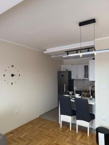 a kitchen with white walls and a table and chairs at Grand Line in Sombor +5 photos