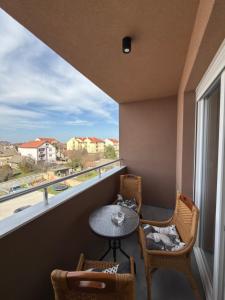 a balcony with a table and chairs and a window at Grand Line in Sombor