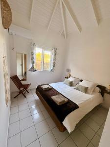 a bedroom with a large bed and a chair at Villa Eli -6pers- piscine in Petit-Bourg +26 photos