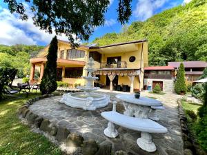 a house with a fountain in front of a building at Pensiunea Un colț de Rai in Lunca Jariştei