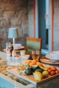 a table with a tray of fruits and vegetables on it at Quinta Clara in Vila Verde