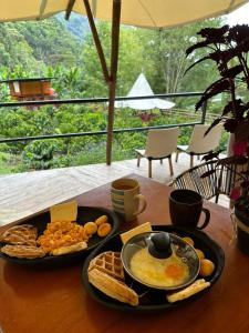 a table with a plate of food and a bowl of eggs at Cabañas AlmA Rural Ibagué in Ibagué