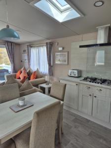a kitchen and living room with a couch and a table at Tower View Retreat, Haven Marton Mere in Blackpool