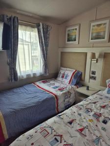 a bedroom with two beds and a window at Tower View Retreat, Haven Marton Mere in Blackpool