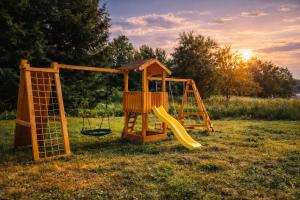 a playground with a swing and a slide at Jaunas Ilgas in Medumi +20 photos