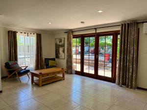 a living room with a table and a bench and sliding glass doors at 31 The Rocks in Stanthorpe