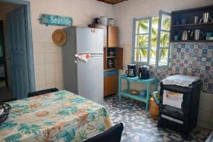 a kitchen with a refrigerator and a table in it at Casinha beira praia Gaivota ,há 2 minutos da praia in Itanhaém