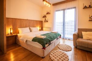 a bedroom with a large bed and a couch at Apartment Vila Jela in Kolašin