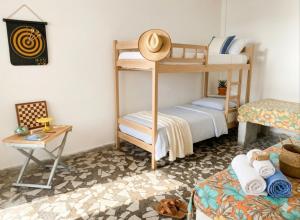 a room with two bunk beds and a table at Casinha beira praia Gaivota ,há 2 minutos da praia in Itanhaém