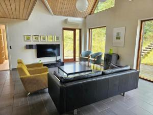 a living room with a black leather couch and chairs at FAN032-Fano-Skovly-4 in Fanø