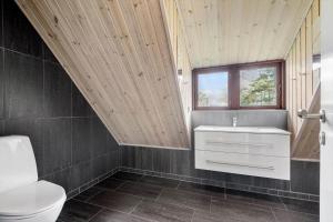 a bathroom with a toilet and a sink and a window at FAN032-Fano-Skovly-4 in Fanø +28 photos
