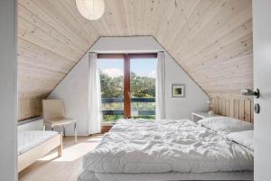 a bedroom with a large bed and a window at FAN032-Fano-Skovly-4 in Fanø