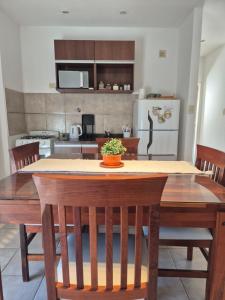 a kitchen with a wooden table with chairs and a kitchen with a refrigerator at Departamento confortable con muy buena ubicacion y cochera para 4 personas in Corrientes