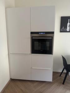 a white cabinet with a microwave oven in it at La Casa di Vale in Ventimiglia +18 photos