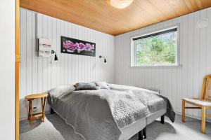 a bedroom with a bed and a window at 198-Ringkobing-Bogealle-8 in Nørby