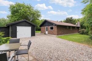 a detached house with a garage and a driveway at 198-Ringkobing-Bogealle-8 in Nørby