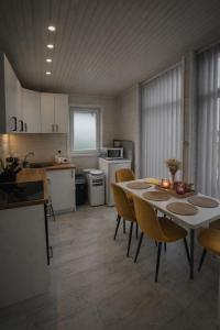 a kitchen and dining room with a table and chairs at Jaunas Ilgas in Medumi