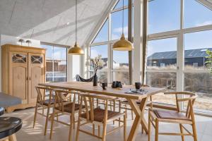 a dining room with a wooden table and chairs at 1159-Ringkobing-Anders-Juhls-Vej-13 in Søndervig