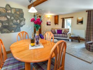 a dining room with a table with a vase of flowers at Yr Hen Felin in Mathry