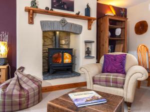 a living room with a fireplace and two chairs at Yr Hen Felin in Mathry +28 photos