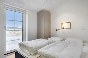 a bedroom with two beds and a large window at 1159-Ringkobing-Anders-Juhls-Vej-13 in Søndervig