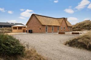a large brick building with a roof on a beach at 1159-Ringkobing-Anders-Juhls-Vej-13 in Søndervig