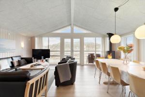 a living room with a couch and a table and chairs at 135-Ringkobing-Sortebaerdalen-51 in Kryle