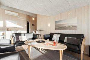 a living room with a couch and a table at 135-Ringkobing-Sortebaerdalen-51 in Kryle