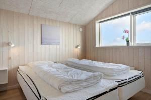 two beds in a room with two windows at 135-Ringkobing-Sortebaerdalen-51 in Kryle