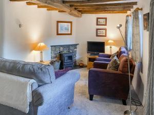 a living room with two couches and a fireplace at Garries Cottage in Bassenthwaite