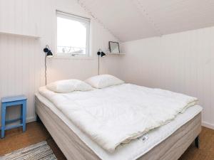 a bedroom with a large white bed with a window at Cozy Retreat by Koge Bay - By Traum Ferienwohnungen in Strøby