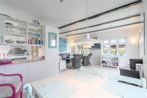 a kitchen and living room with a table and chairs at 085-Ringkobing-Nordsovej-68 in Søndervig +18 photos