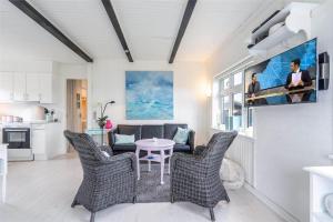a living room with a table and chairs and a kitchen at 085-Ringkobing-Nordsovej-68 in Søndervig