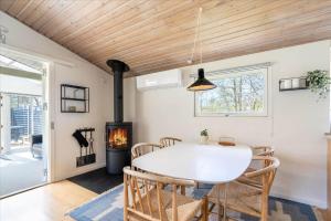 a dining room with a table and a fireplace at 156-Ringkobing-Birkealle-14 in Nørby +33 photos