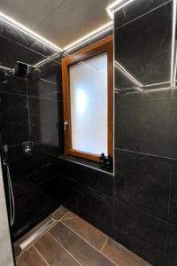 a bathroom with a glass shower with a window at Alloggio Manzoni in Asti +6 photos