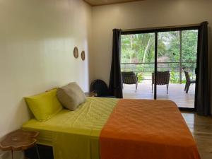 a bedroom with a bed and a deck with a patio at Casa Morpho in Zancudo