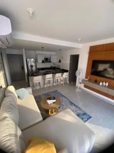 a living room with a white couch and a kitchen at Golden Breeze in Cartagena de Indias